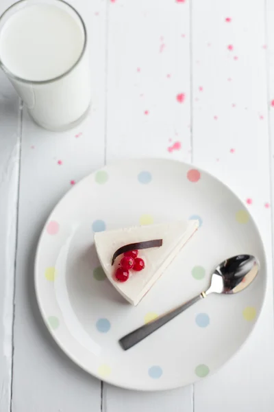 Weißer Käsekuchen mit roten Beeren auf einem Holztisch. Stillleben — Stockfoto