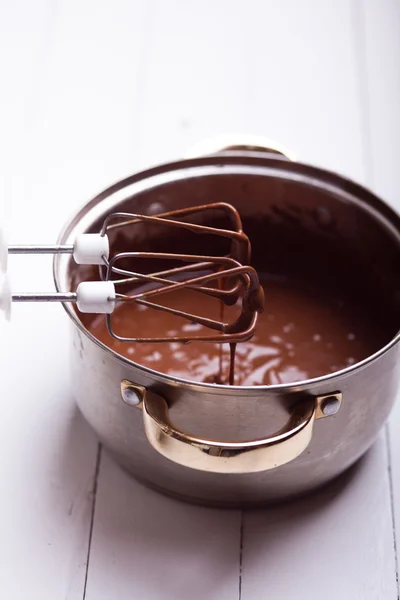 Jarabe de chocolate que gotea de la herramienta de cocina en la mesa — Foto de Stock