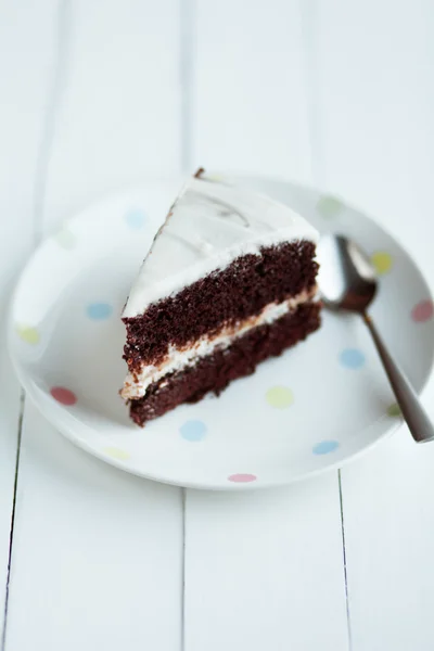 Шоколадний торт у білій тарілці на дерев'яному столі — стокове фото