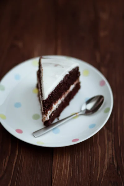 Шоколадний торт у білій тарілці на дерев'яному столі — стокове фото