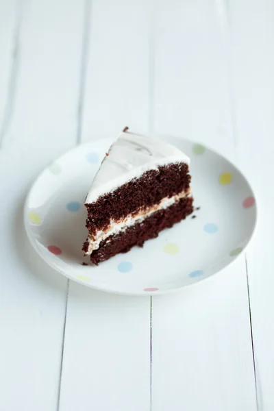 Schokoladenkuchen in weißem Teller auf Holztisch — Stockfoto