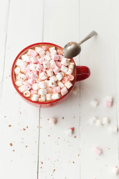 Horká čokoláda s marshmallows v červené cup na stole — Stock fotografie