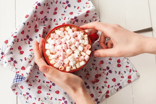 Handen met warme chocolademelk met marshmallows in cup — Stockfoto