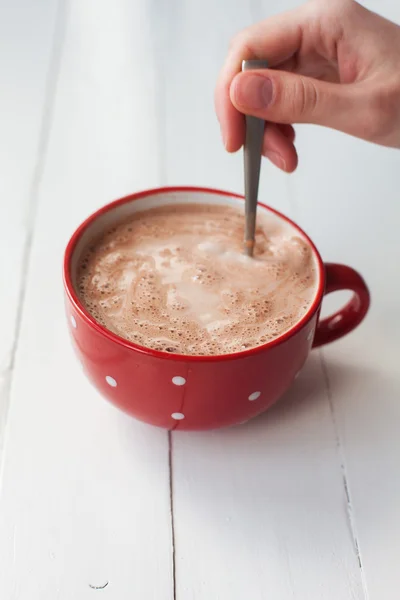 Femme main tenant cuillère dans une tasse de chocolat dans une tasse — Photo
