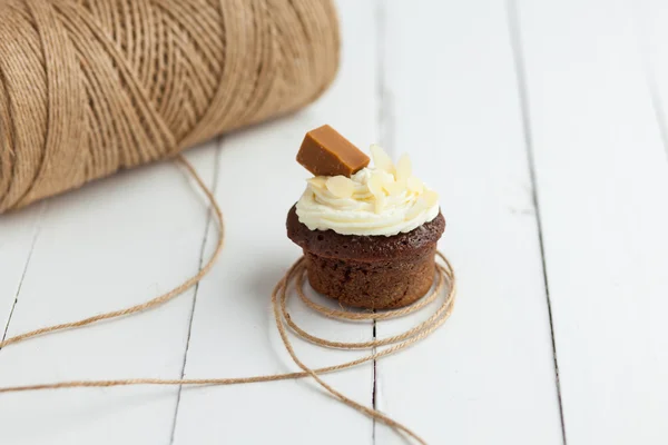 Свежий шоколадный кекс с ирисом и миндалем на деревянном столе — стоковое фото