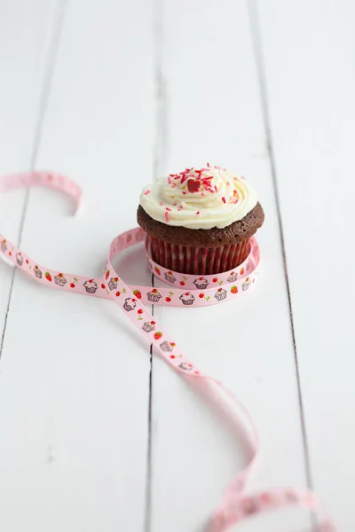 Decorated chocolate muffin on wooden table — Stock Photo, Image