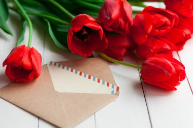 Taze laleler ve ahşap masa arka plan üzerinde mektup