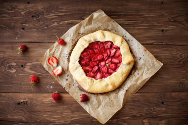 Ev yapımı Galette'ye ahşap masa üzerinde çilek ile