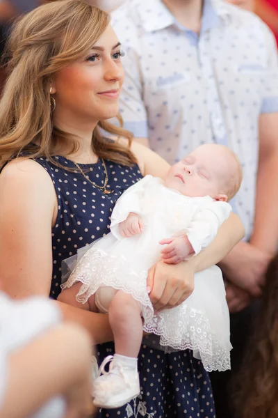 Gelukkig moeder met baby op de doop ceremonie in de kerk — Stockfoto