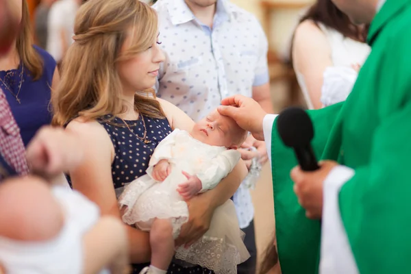 Moeder houden baby op ceremony van kind doop in kerk — Stockfoto
