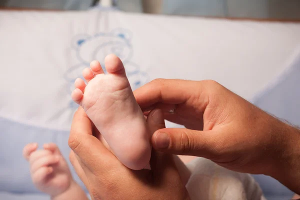 Masajista masajeando pequeño pie de bebé — Foto de Stock