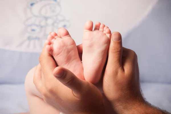 Baby nohy na rodiče rukou — Stock fotografie