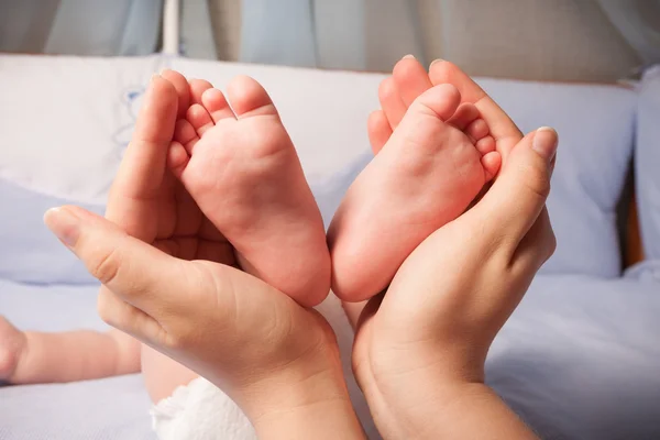 Baby fötter på föräldrar händer — Stockfoto
