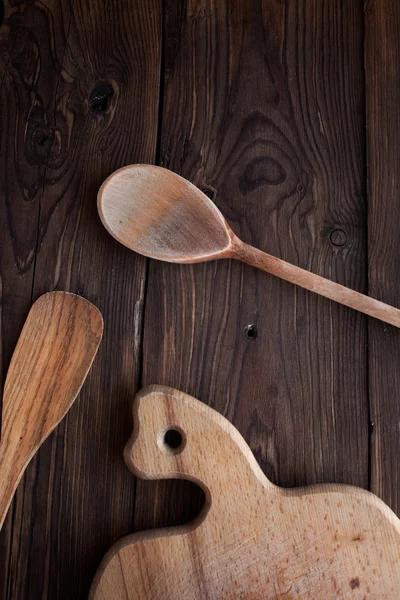 Cuchara de madera con herramientas de cocina en la mesa vieja — Foto de Stock