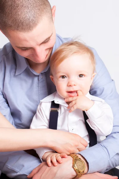 Liten pojke på far händer ser till kamera — Stockfoto