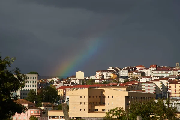 cloudy city with realistic rainbow and white houses and buildings from Ourense. rainbow in ourense