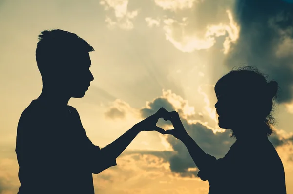 サンレイ神明るい背景 バレンタイン背景とハートに手を触れて 夕日の中にシルエットを愛のカップル — ストック写真