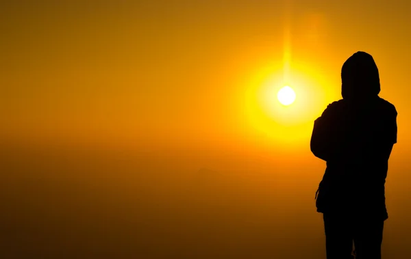 Siluet manusia berdiri di atas warna-warni matahari latar belakang cahaya — Stok Foto