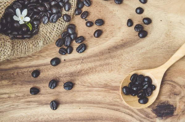 Studio Shot de granos de café en una bolsa con mesa de madera —  Fotos de Stock