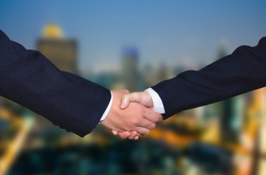 Başarılı iş adamları el sıkışarak anlaşma yapıyor.