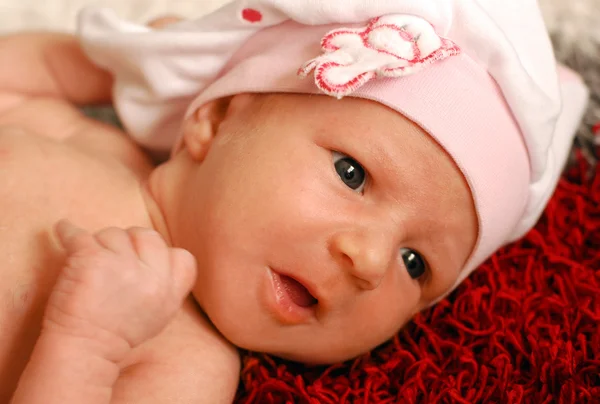 Портрет милой маленькой девочки с большими голубыми глазами в розовой шляпе — стоковое фото