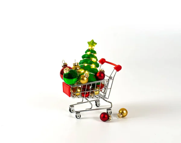 クリスマスボールとガーランドとツリーでショッピングトロリー 平面背景 — ストック写真