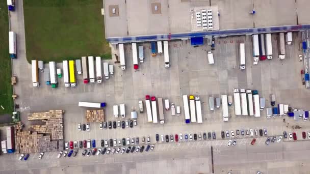 Luchtfoto van magazijn met vrachtwagens. Industriële achtergrond. Logistiek van bovenaf. Luchtfoto 's van de drone. — Stockvideo