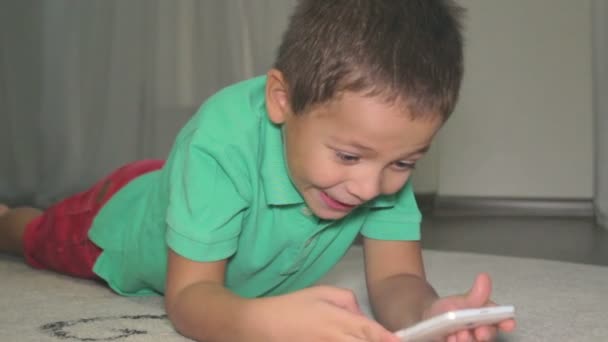 Καυκάσιος αγόρι παίζει παιχνίδι στο τηλέφωνο. — Αρχείο Βίντεο