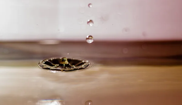 Desembarque de gotas de água na água — Fotografia de Stock