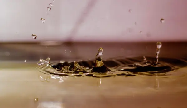 Desembarque de gotas de água na água — Fotografia de Stock