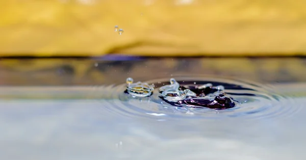 Desembarque de gotas de água na água — Fotografia de Stock