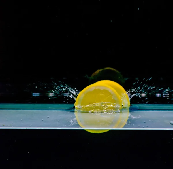 Limone in acqua, isolato su fondo nero — Foto Stock