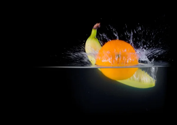 Obst spritzt ins Wasser — Stockfoto