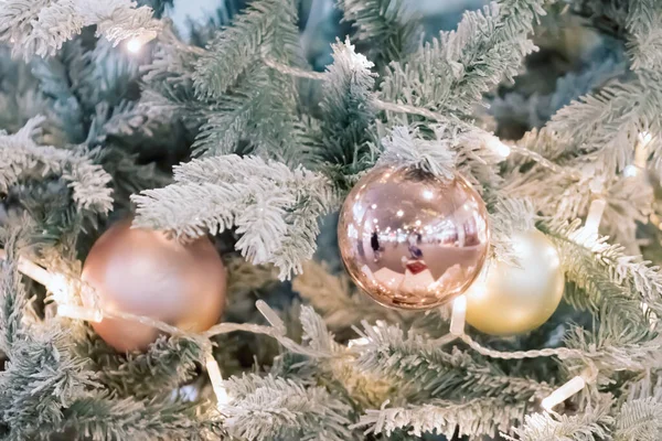 Bollar och kransar hänger på tallkvistar på festlig bakgrund. Guldgranskulor på granen. Julbakgrund. God Jul och Gott Nytt År Vykort. — Stockfoto