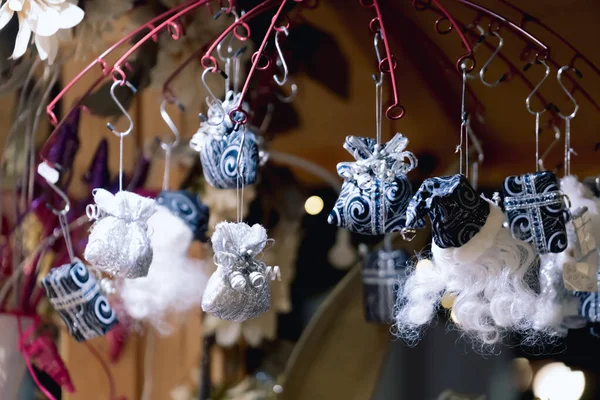 Christmas decorations on street market - hanging toys on blurred background. Abstract christmas backdrop. Selective focus