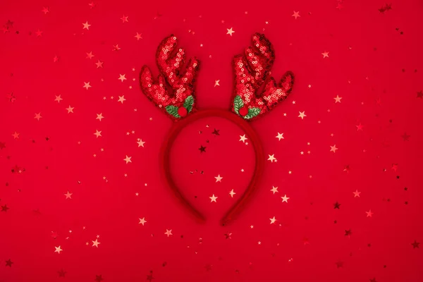 圣诞驯鹿鹿角头带上的红色闪光表面,贺卡.节日服装细节，圣诞鹿角。头发上的圣诞装饰。最小寒假的想法。平躺在床上 — 图库照片