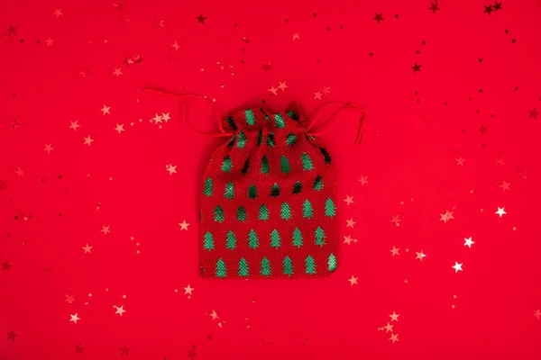 圣诞袋装玩具的构图极小.红色表面的圣诞纺织品装饰。俯瞰，平铺 — 图库照片
