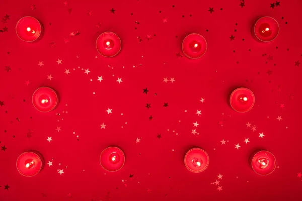 圣诞夜晚或情人节的构图由燃烧的蜡烛制成，在红色的表面闪烁着光芒。圣诞快乐，2021年新年快乐，情人节快乐。平躺在床上 — 图库照片