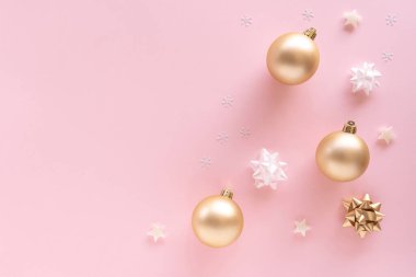 Noel kompozisyonu. Hediye, takılar, tebrik kartı, pastel pembe yüzeyde altın süslemeler. Noel, kış, yeni yıl konsepti. Düz konum, üst görünüm, kopyalama alanı