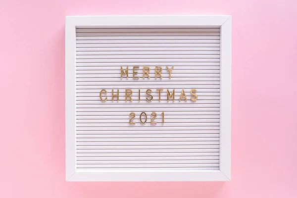 Brievenbord met Vrolijk Kerstfeest 2021 begroeting, begroeting quote op brievenbord op roze pastel girly achtergrond. Vlakke lay, van boven — Stockfoto