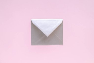 Pastel pembe arka planda tebrik kartı olan gümüş bir zarf. Tebrik mektubu, Noel Baba 'ya mektup. Noel ya da Yeni Yıl 2021 minimum konsept. Yukarıdan görüntüle