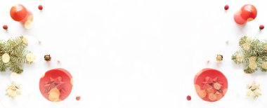 Beyaz yüzeyde Noel kompozisyonu. Hediye kutusu, tatil süslemeleri, köknar dalı, mum. Noel romantik konsepti. Düz döşeme, kopyalama alanı, pankart