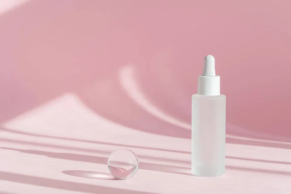 Kolajenle serum yağı ve beyaz şeffaf şişede peptit ve gölgeli pembe dekor arkaplanı üzerine damlatıcı. Cilt bakımı, tıbbi cilt bakımı, makyaj ürünleri.