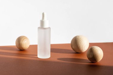 Deri nemlendirici serumu beyaz kahverengi arka planda dekorlu. Güzellik derisi maketi, markalaşma spa, sağlık paketi. Serum eko kozmetik ürünü. Doğal kozmetik konsepti.