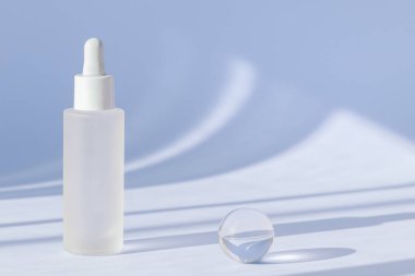 Anti aging serum with collagen and peptides on blue surface with shadows. Hyaluronic acid oil mockup. Sunlight and shadow from serum cosmetic. Transparent liquid product in glass bottle clipart