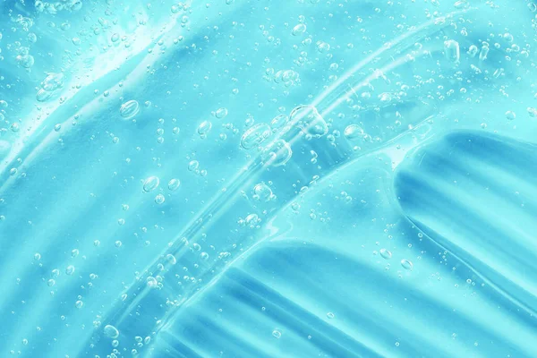蓝色的凝胶清洁剂抹布。抗菌卫生洁肤水花。用芦荟和胶原蛋白对水合产物进行结冰处理.更干净的纹理。液体清澈果冻涂片.血清、洗发水或剃须膏 — 图库照片
