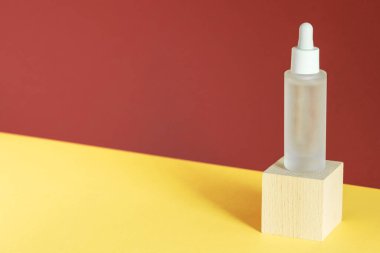 Kolajen ve peptidli serum, tahta küp podyumda. Hiyalüronik asit yağ tentürü, kaidesel vitrinde. Güzellik ürünü maketi. Ürün reklamı, doğal kozmetik konsepti