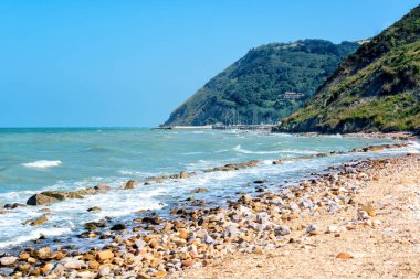 Deniz manzaralı güzel bir deniz manzarası ve yaz günü dağları çakıl taşları ve sularla dolu deniz kıyıları. Adriyatik kıyıları, Rimini, İtalya