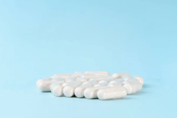 Medicamentos o cápsulas de suplemento en la superficie azul. Píldoras farmacéuticas, tabletas y vitaminas. —  Fotos de Stock