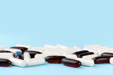 İlaç hapları ve vitaminler. Mavi yüzeyde ilaç ya da takviye kapsülleri. Probiyotik, inulin, glukozamin yığını.